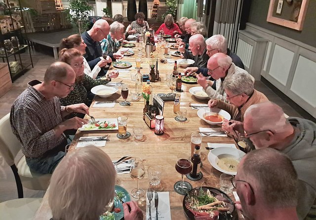 vrijwilliges van de molen aan tafel tijden het aflsuitende diner